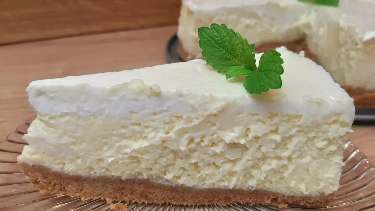 Pyszne, kremowe ciasto z serem na kruchym spodzie, udekorowane listkiem mięty. Idealne na deser.