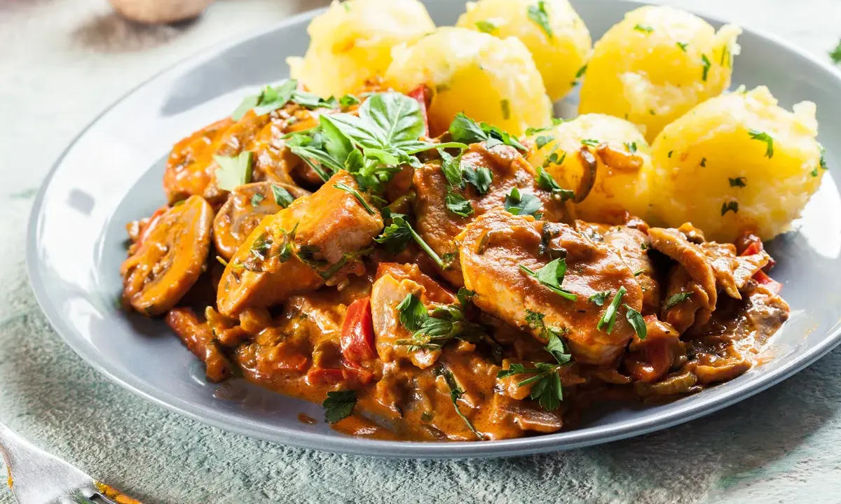 Sznycle z indyka w sosie z pieczarkami i papryką, podane z ziemniakami. Idealny przepis na sznycle z indyka z piekarnika.