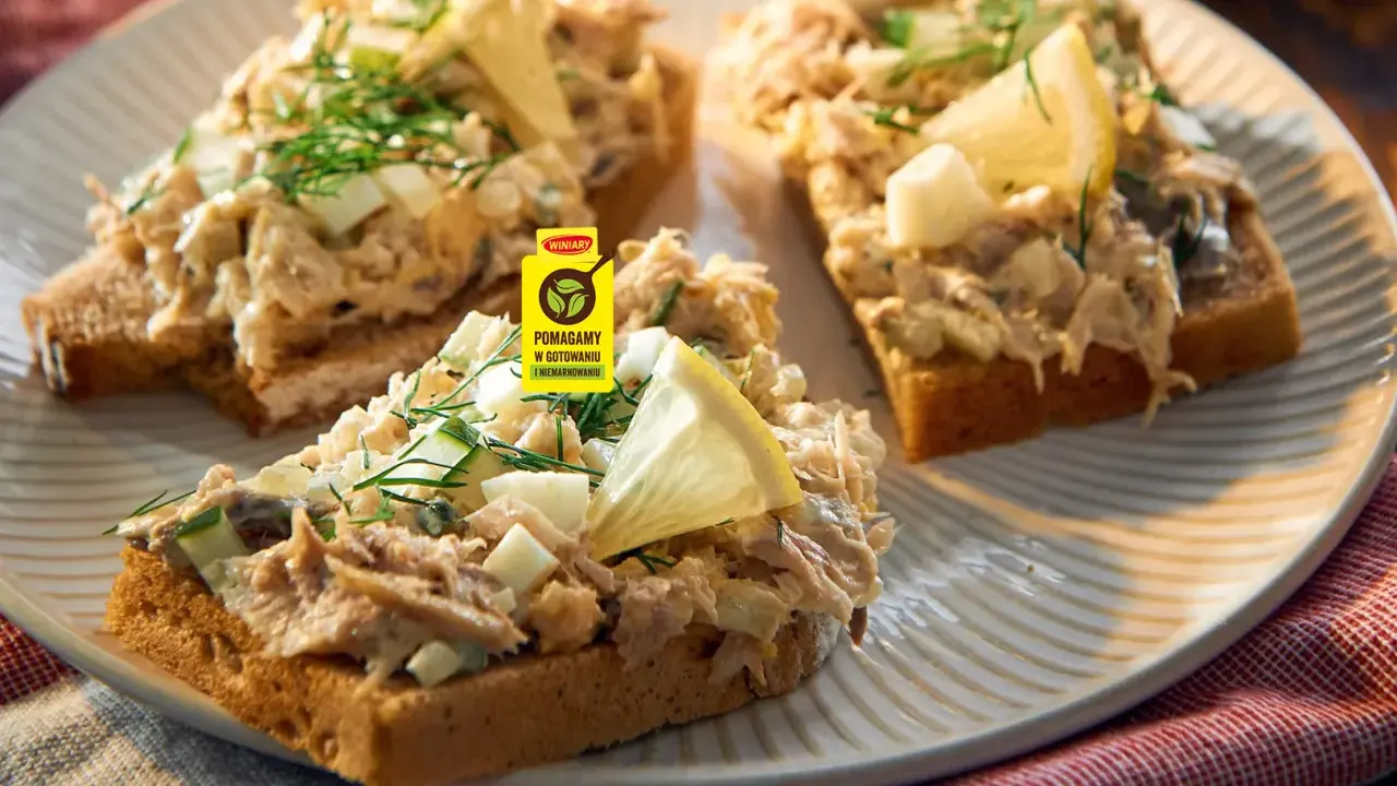 Pyszna pasta z makreli na grzankach z jajkiem i ogórkiem, ozdobiona koperkiem i cytryną. Idealna na szybką przekąskę.