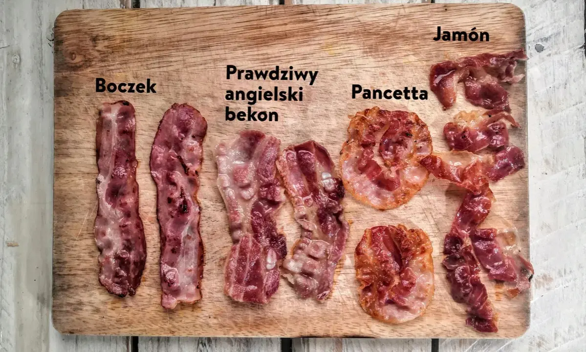 Różne rodzaje bekonu i boczku: boczek, prawdziwy angielski bekon, pancetta i jamón na drewnianej desce.