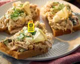 Pyszna pasta z makreli na grzankach z jajkiem i ogórkiem, ozdobiona koperkiem i cytryną. Idealna na szybką przekąskę.