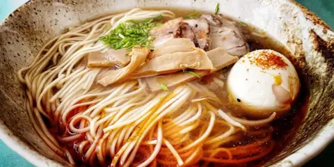A miseczce z makaronem, mięsem, bambusem i jajkiem na twardo. To jest pyszne ramen.