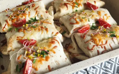Pyszna tortilla z mięsem mielonym, zapieczona z serem, pomidorkami i kiełkami. Idealna na szybki obiad.