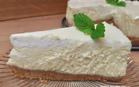 Pyszne, kremowe ciasto z serem na kruchym spodzie, udekorowane listkiem mięty. Idealne na deser.