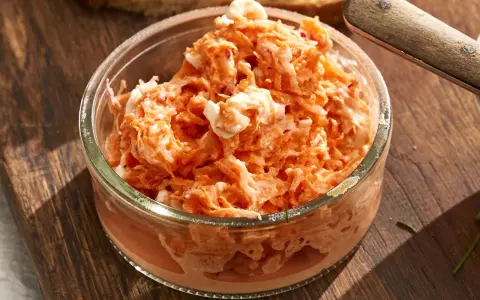 Pyszna pasta z rzodkiewki z kawałkami jajka w szklanej miseczce, gotowa do podania na chlebie.