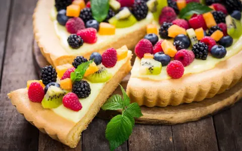 Pyszna tarta na słodko z kremem i mnóstwem świeżych owoców: malin, borówek, jeżyn i kiwi.