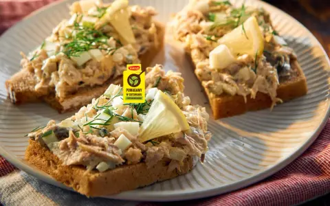 Pyszna pasta z makreli na grzankach z jajkiem i ogórkiem, ozdobiona koperkiem i cytryną. Idealna na szybką przekąskę.