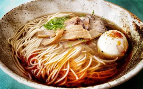 A miseczce z makaronem, mięsem, bambusem i jajkiem na twardo. To jest pyszne ramen.