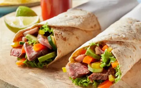 Dwa sycące wrapy z tortilli z soczystą wołowiną, chrupiącymi warzywami i świeżą sałatą. Idealne na szybki lunch.