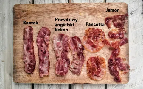 Różne rodzaje bekonu i boczku: boczek, prawdziwy angielski bekon, pancetta i jamón na drewnianej desce.