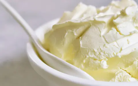 Kremowa masa w miseczce, idealna jako zamiennik mascarpone do deserów.