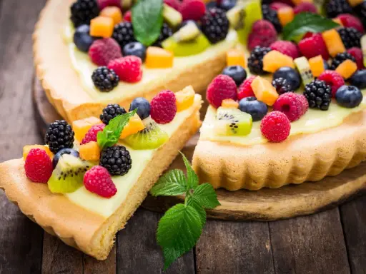Pyszna tarta na słodko z kremem i mnóstwem świeżych owoców: malin, borówek, jeżyn i kiwi.