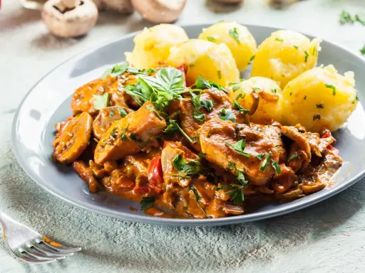 Sznycle z indyka w sosie z pieczarkami i papryką, podane z ziemniakami. Idealny przepis na sznycle z indyka z piekarnika.