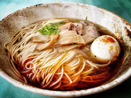 A miseczce z makaronem, mięsem, bambusem i jajkiem na twardo. To jest pyszne ramen.