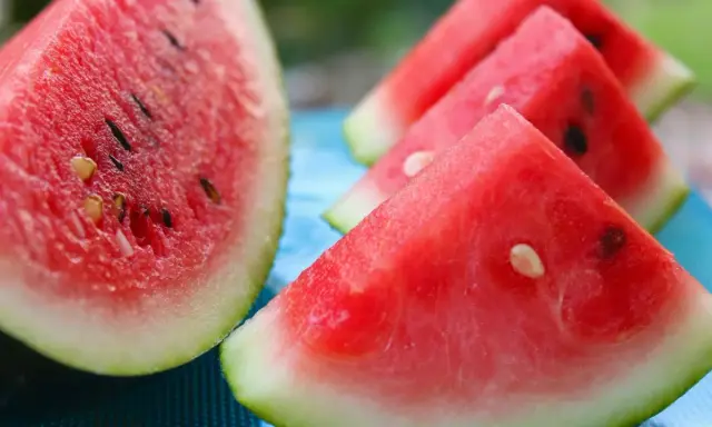 Soczyste kawałki arbuza na niebieskim tle. Dowiedz się, jak wybrać arbuza, by był słodki i dojrzały.