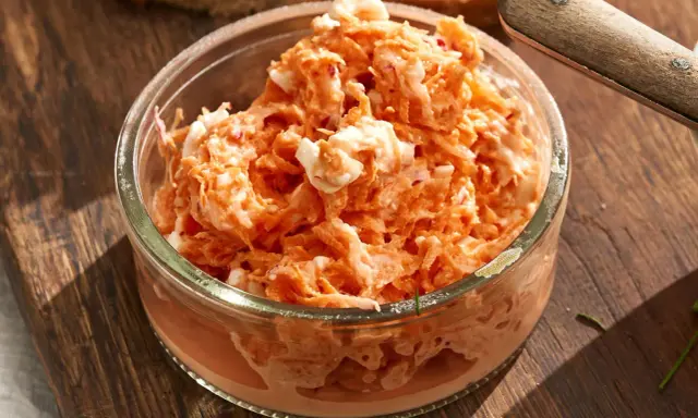 Pyszna pasta z rzodkiewki z kawałkami jajka w szklanej miseczce, gotowa do podania na chlebie.