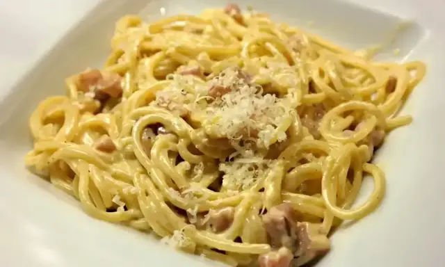 Pyszne spaghetti carbonara z kawałkami boczku i startym parmezanem. Jaki ser do carbonary? Tylko najlepszy!