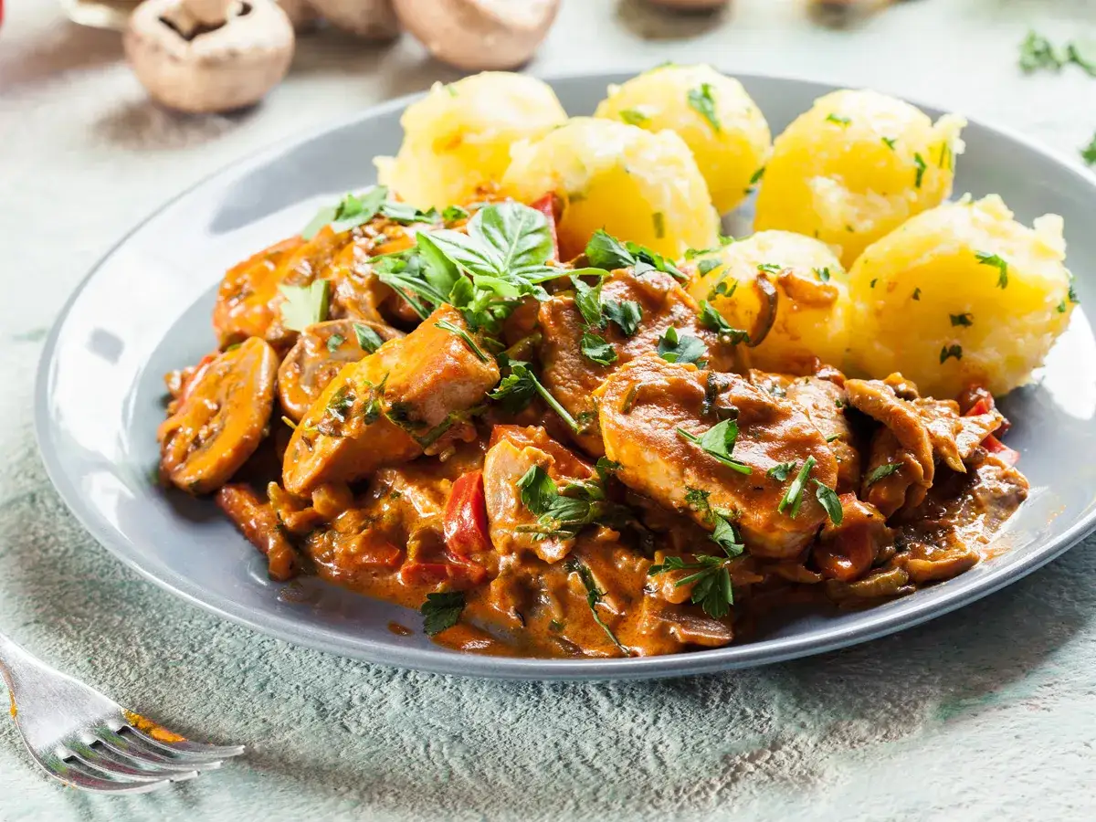 Sznycle z indyka w sosie z pieczarkami i papryką, podane z ziemniakami. Idealny przepis na sznycle z indyka z piekarnika.