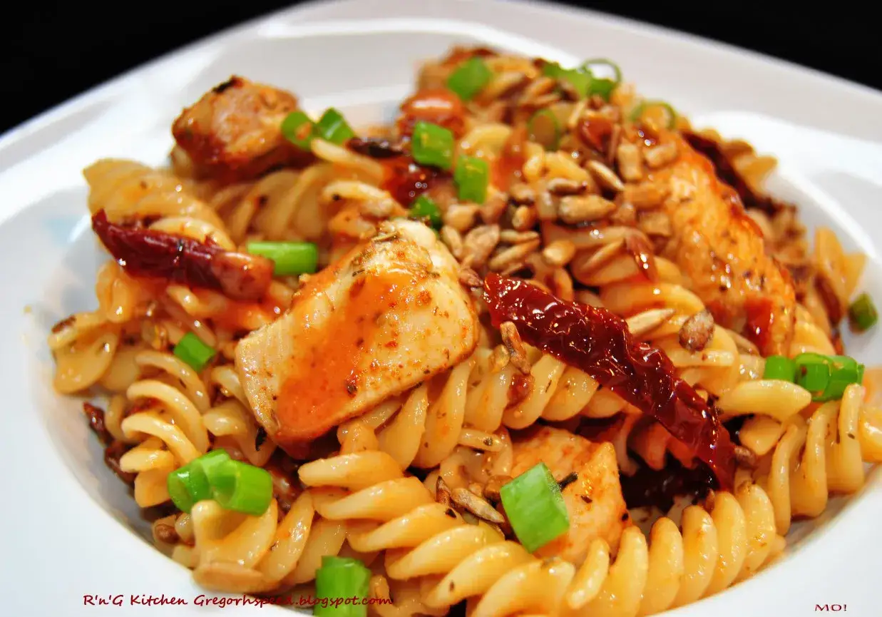 Pyszna pasta z kurczaka z suszonymi pomidorami, pestkami słonecznika i szczypiorkiem.