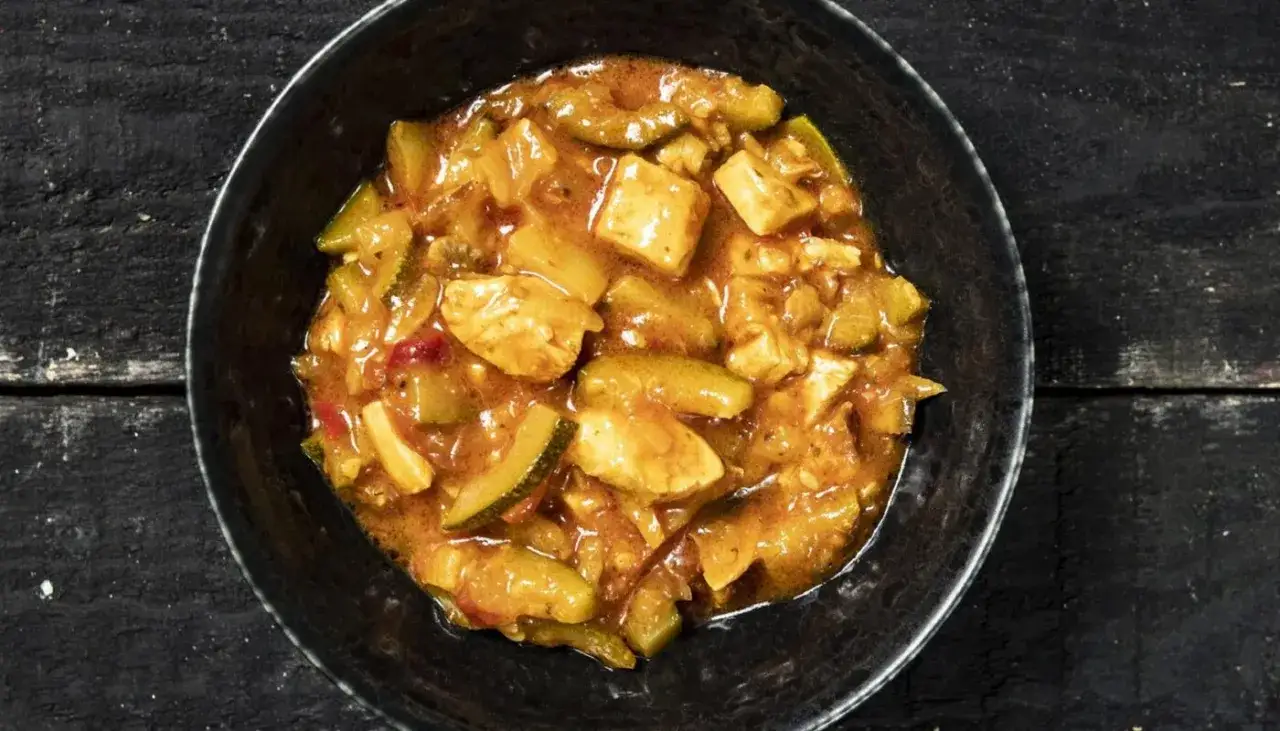Aromaticzne leczo z kurczakiem w głębokiej misce, pełne kawałk&oacute;w mięsa i warzyw, gotowe do podania.