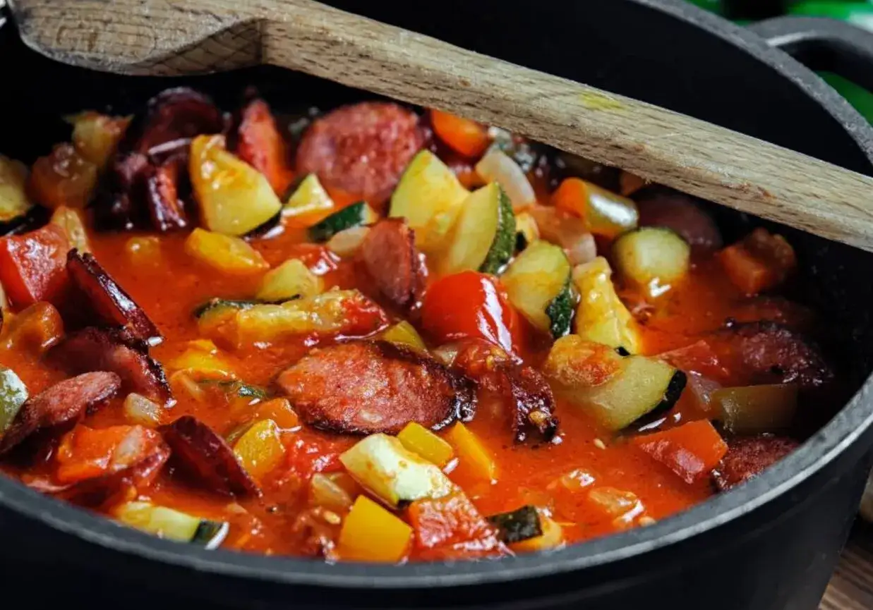 Gęste, aromatyczne leczo z pieczarkami, kiełbasą i warzywami w sosie pomidorowym, gotowe do podania.