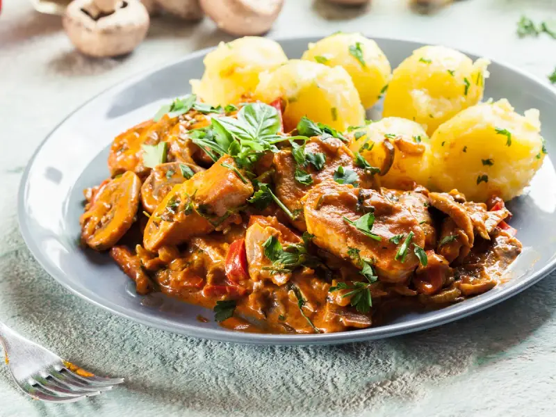 Sznycle z indyka w sosie z pieczarkami i papryką, podane z ziemniakami. Idealny przepis na sznycle z indyka z piekarnika.
